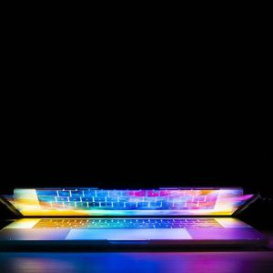 An image of an almost closed laptop with illuminating light coming from the screen.